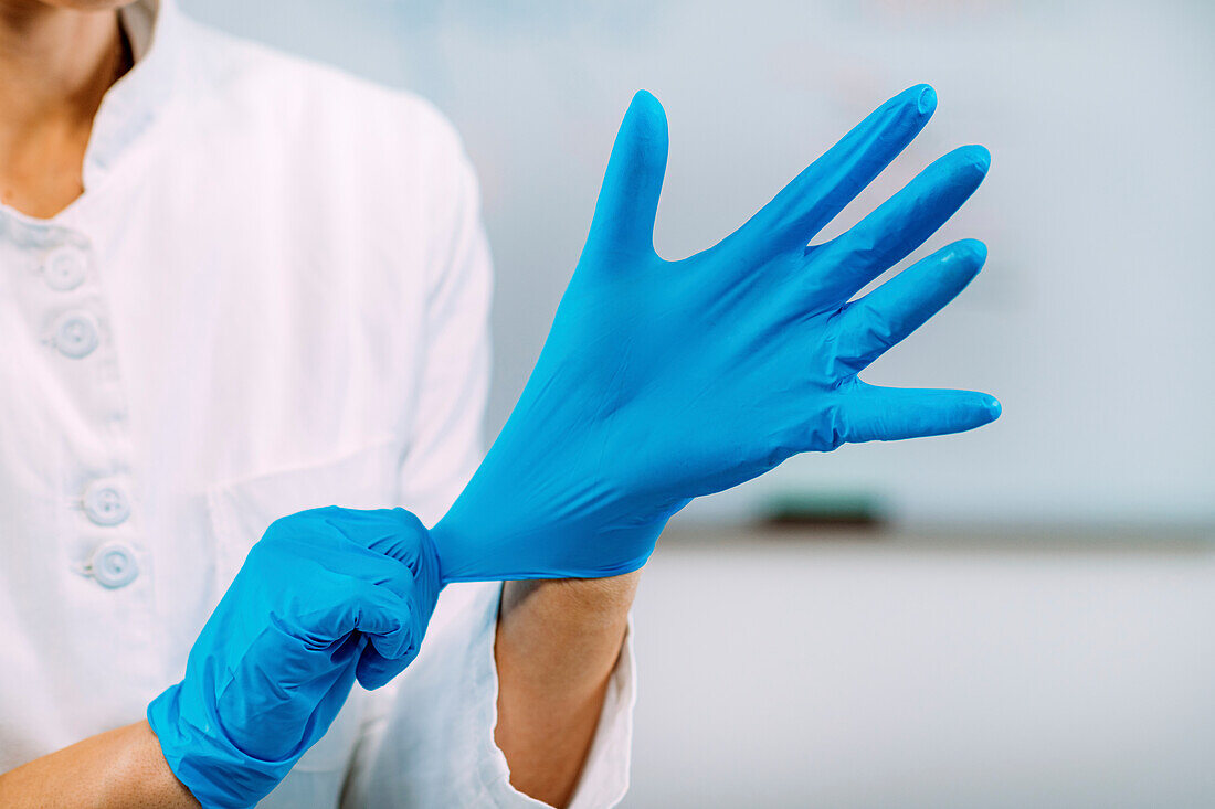 Lab technician putting on protective gloves