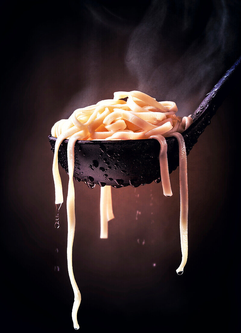 Ladle of cooked fettuccine