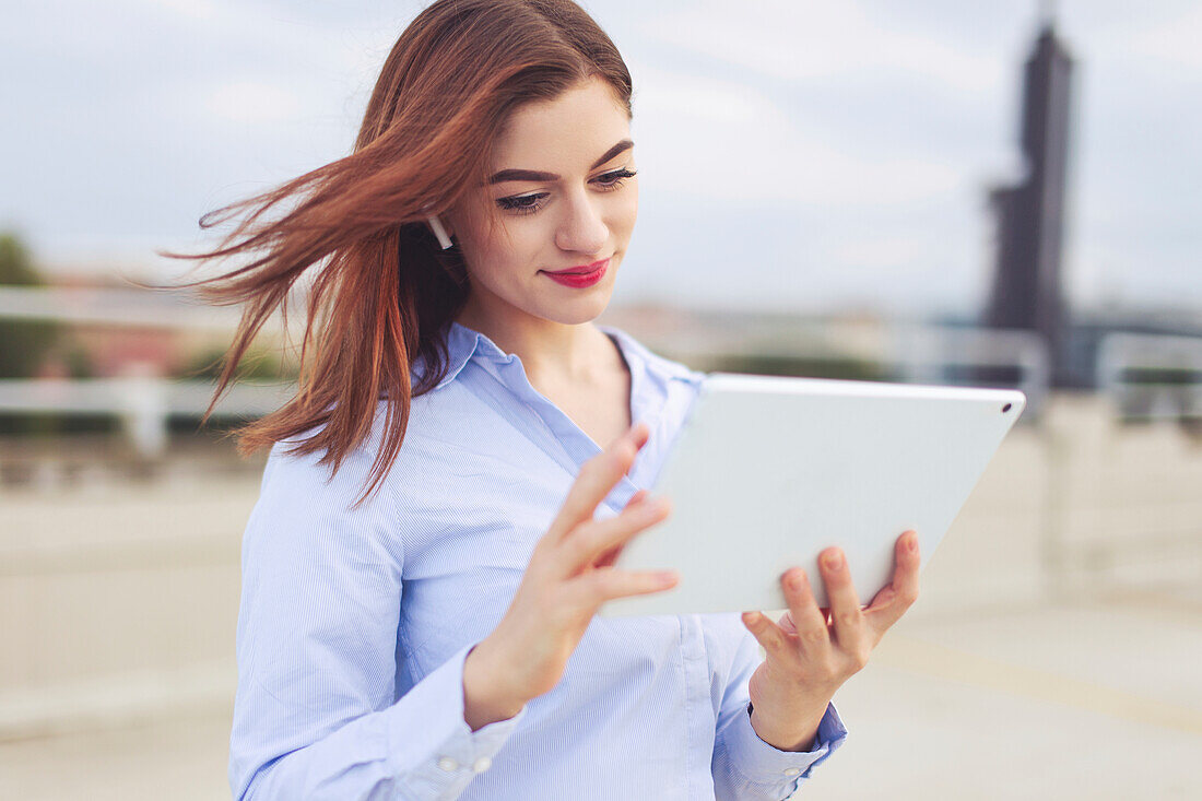 Businesswoman using tablet outdoors