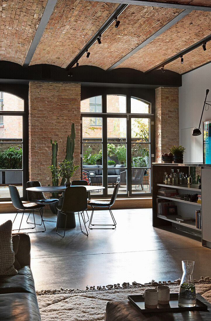 Loft living room with vaulted brick ceiling and floor-to-ceiling windows