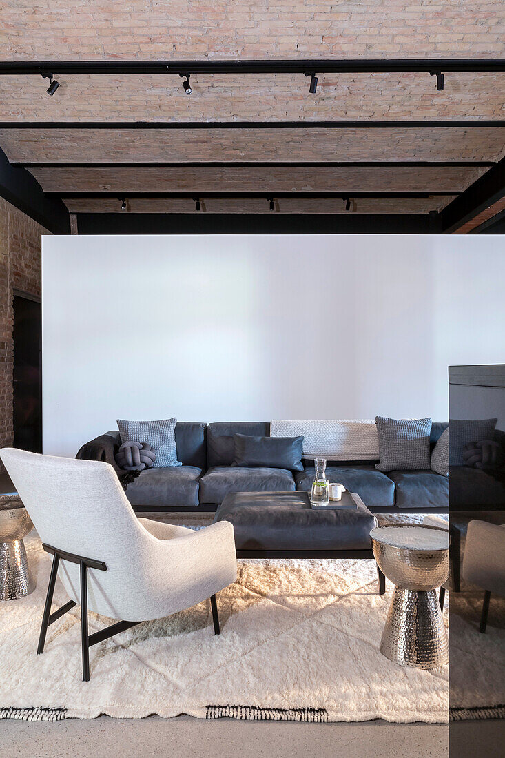 Loft living room with blue leather couch and white armchair