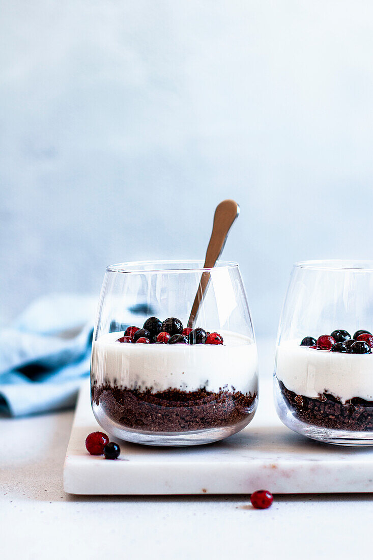Trifle with chocolate cookies, yoghurt and blackcurrants