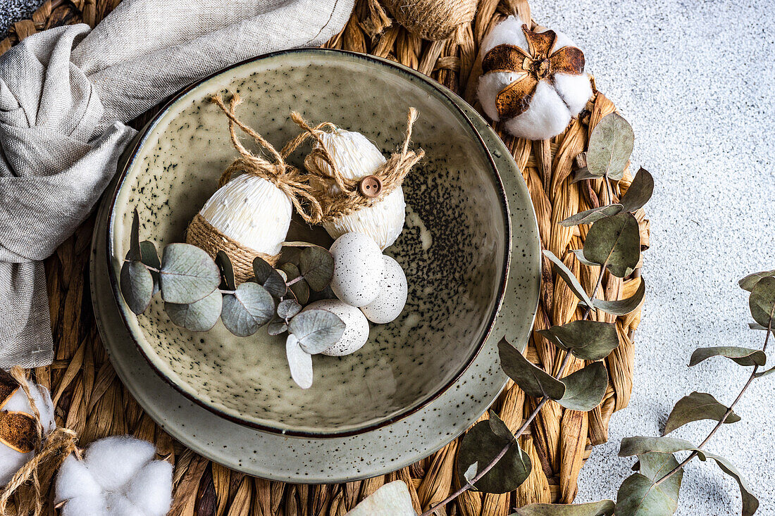 Easter festive table setting with tiny eggs and tableware on stone background