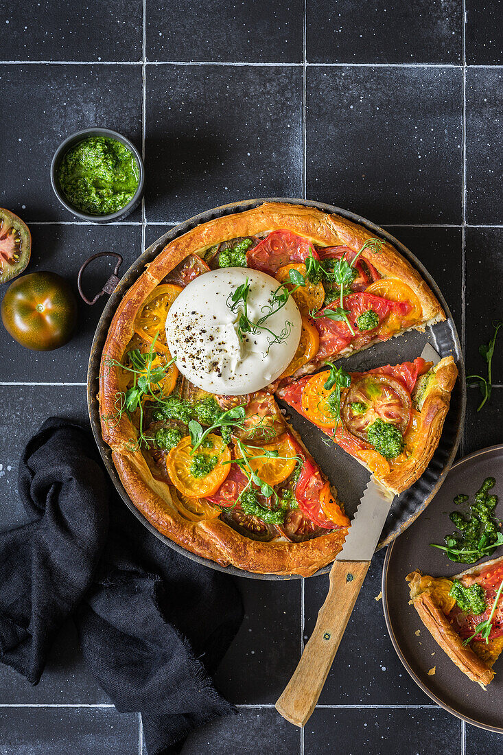 Puff pastry tomato tart with pesto, green pea sprouts and burrata cheese