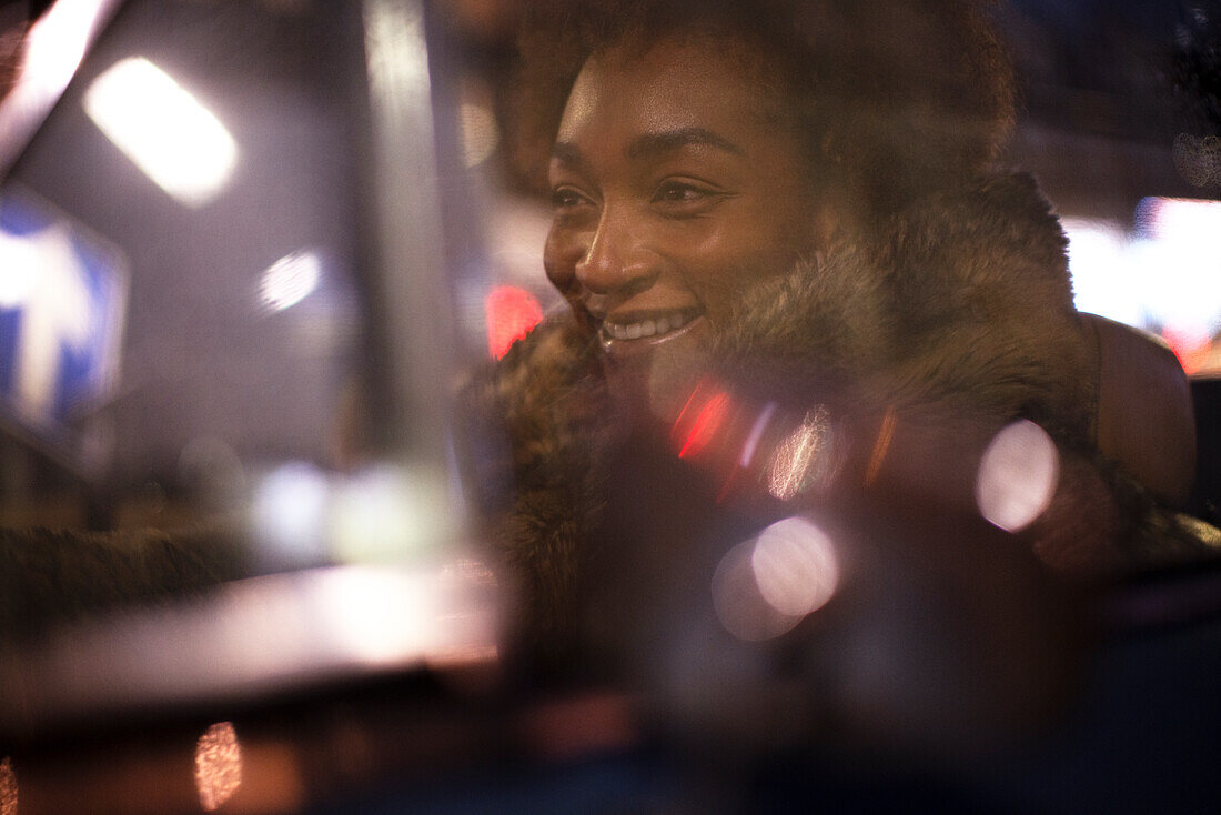 Happy young woman in car at night