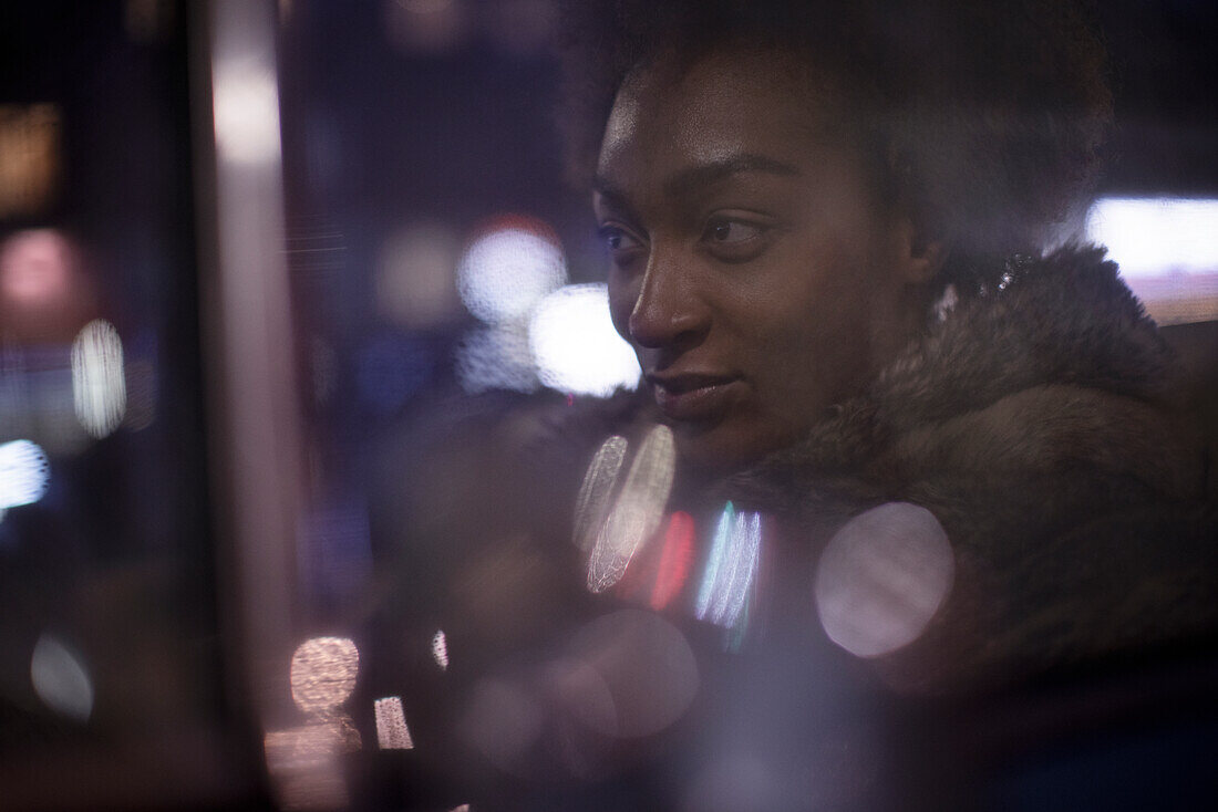 Young woman in car window at night