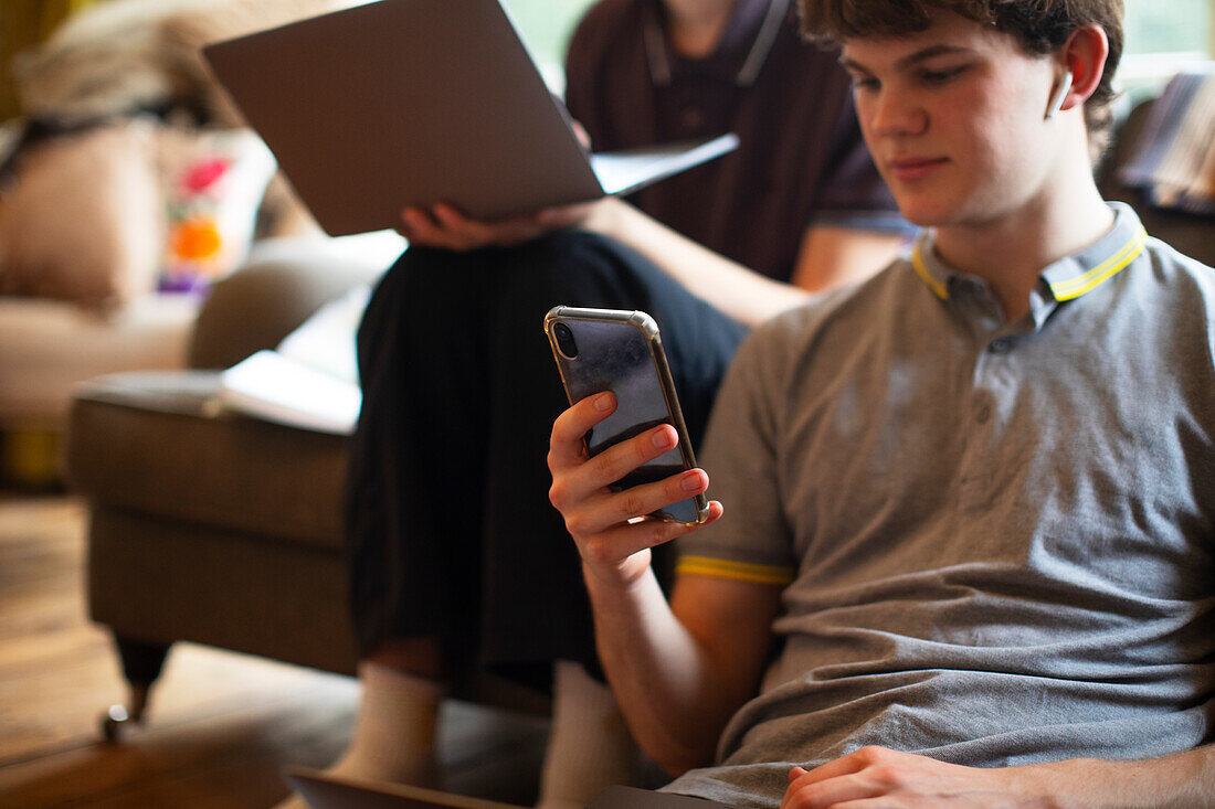Teenage boy using smartphone at home