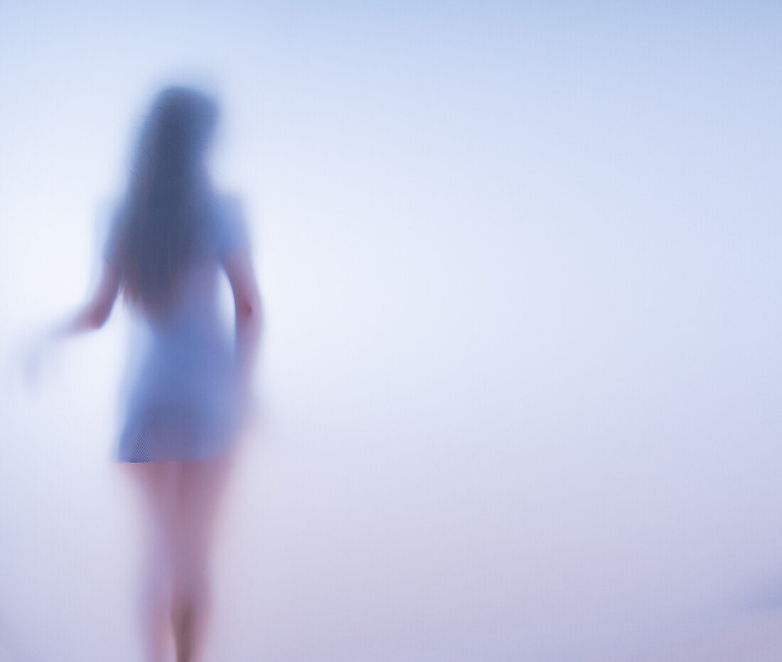 Woman in a short dress behind frosted glass