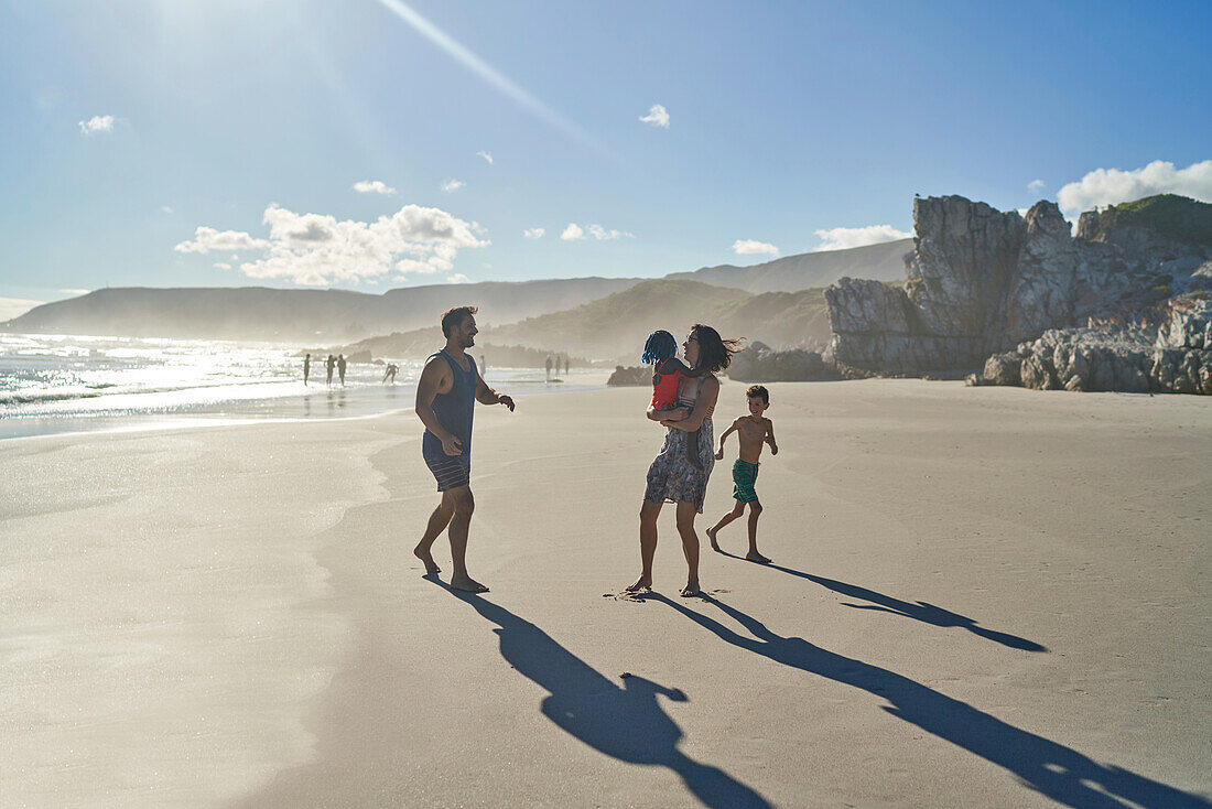 Family playing on sunny summer beach