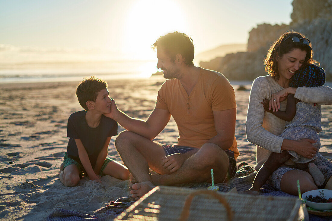 Happy family enjoying picnic on summer beach