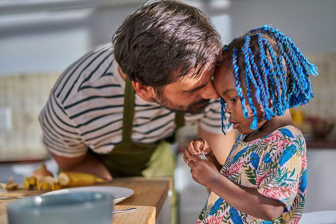 Affectionate father and cute toddler daughter in kitchen