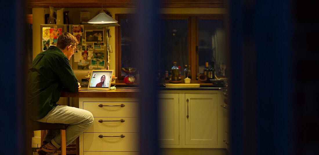 Man working late video conferencing with colleagues