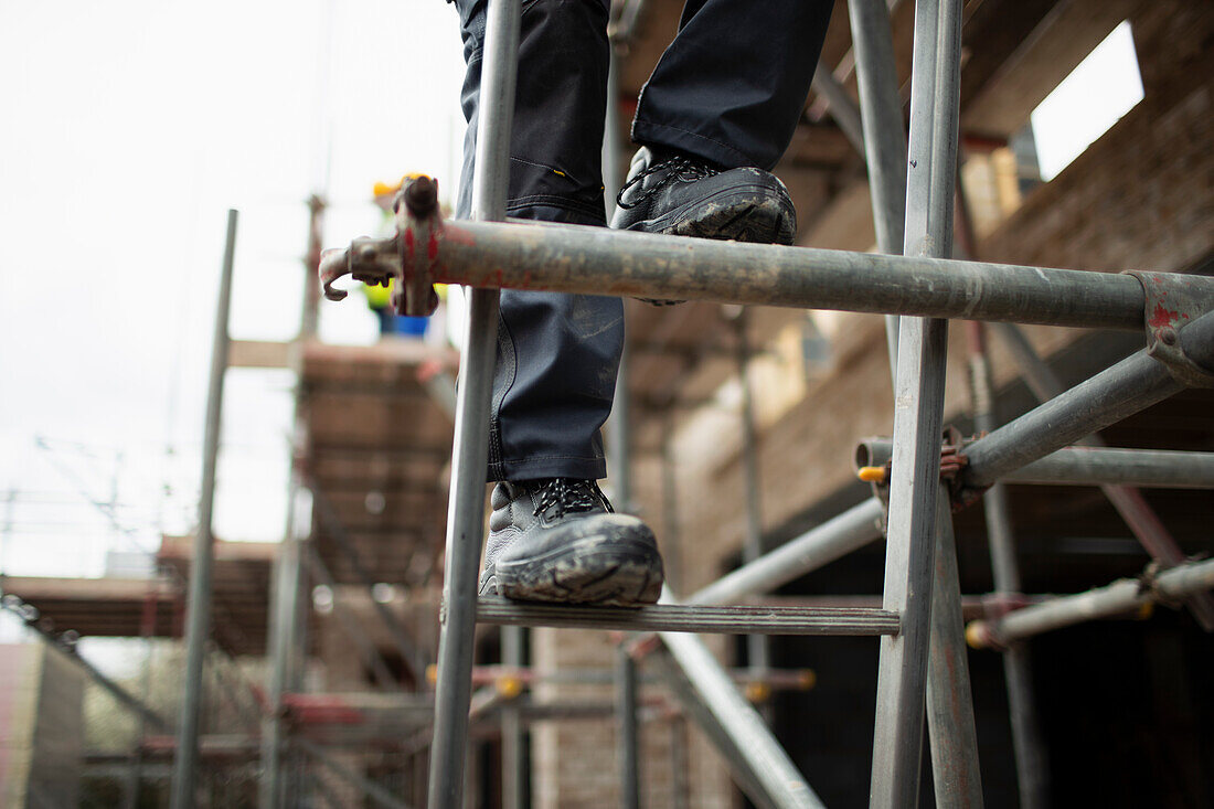 Construction worker climbing scaffolding