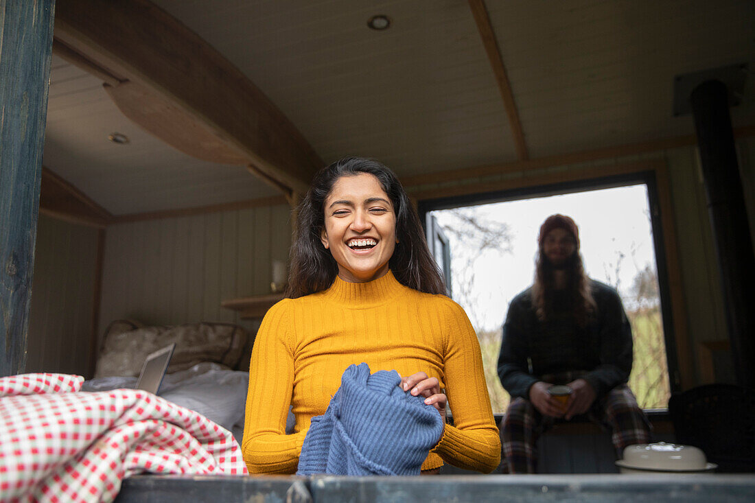 Happy young woman laughing in tiny cabin rental