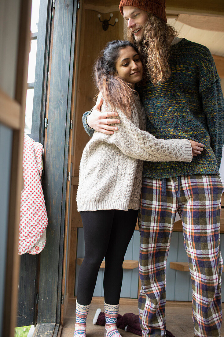 Happy young couple in pyjamas hugging