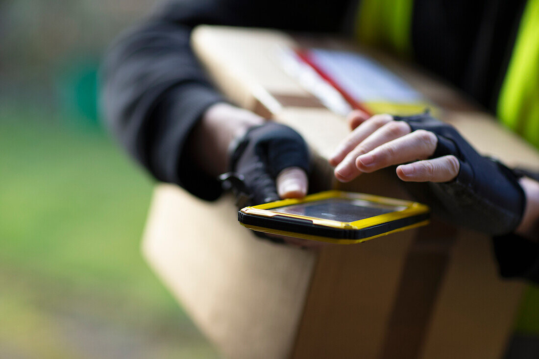 Courier with smartphone delivery package