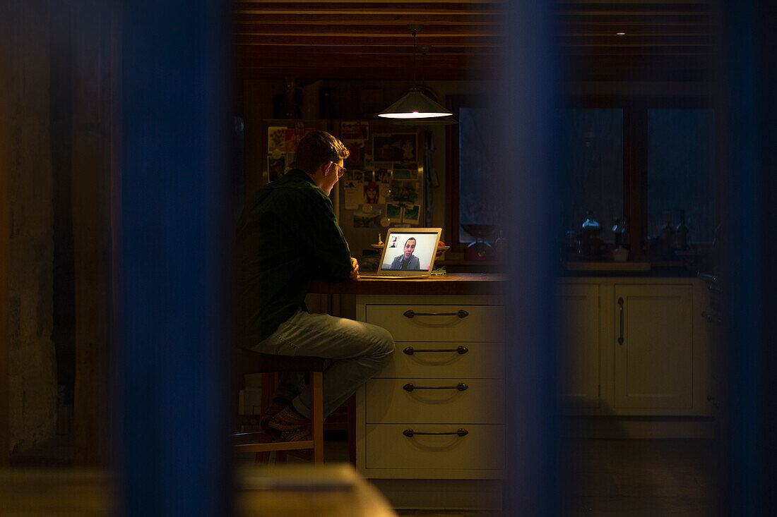 Man working late video conferencing on laptop