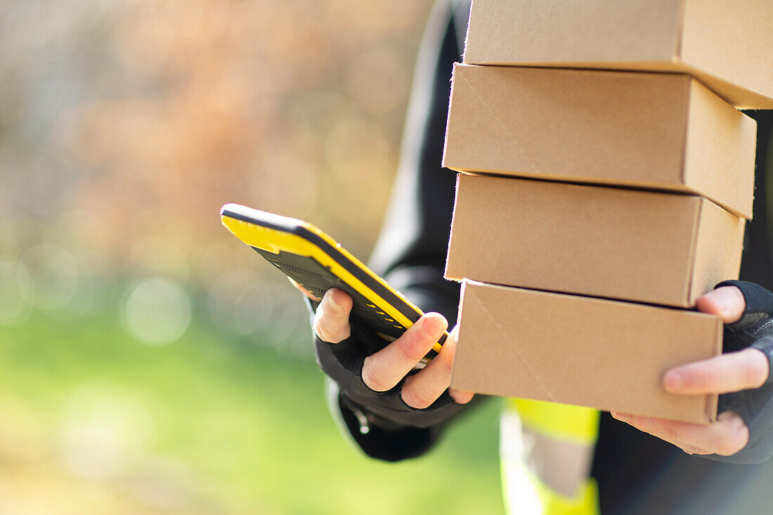 Courier with smartphone delivering packages