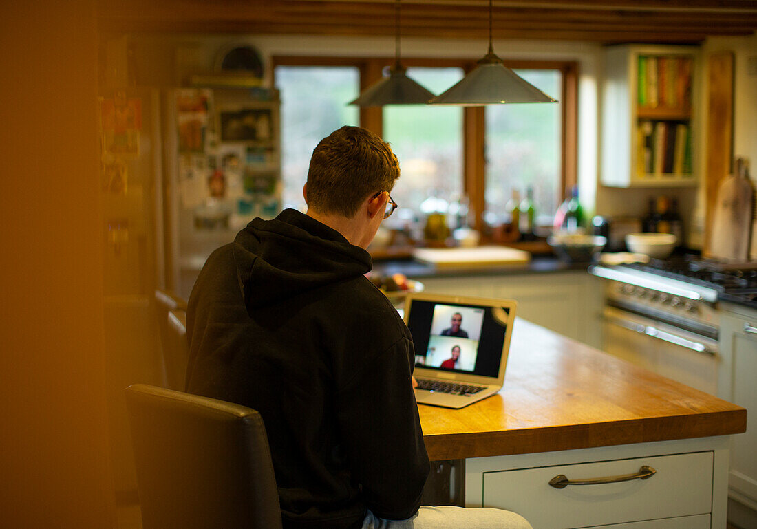 Man working at home video chatting with coworkers