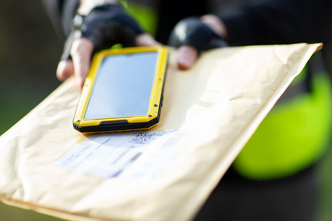 Courier with smartphone delivering envelope