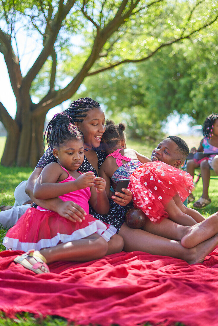 Happy family relaxing on blanket in park