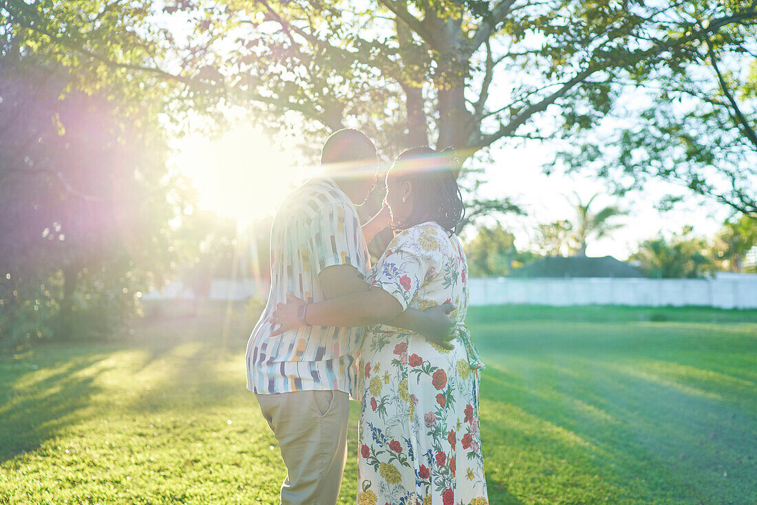 Happy couple dancing in sunny backyard