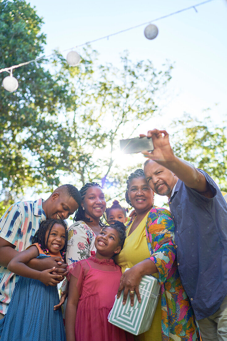 Happy multigenerational family taking selfie in backyard