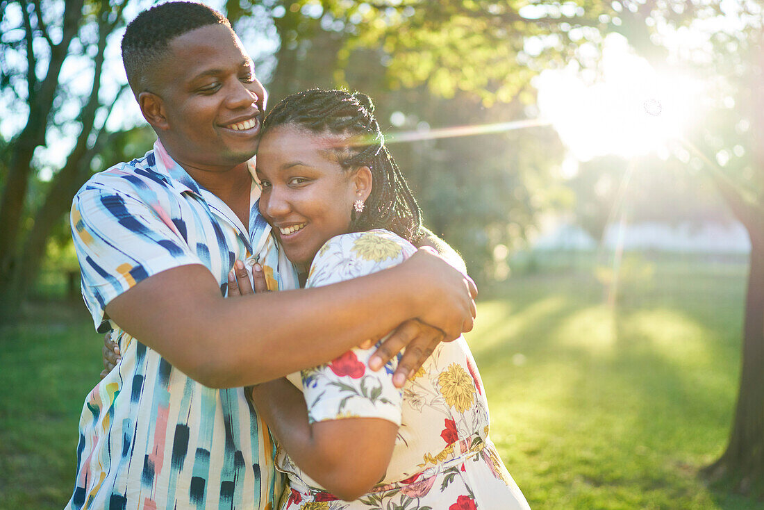 Happy couple hugging in sunny summer park