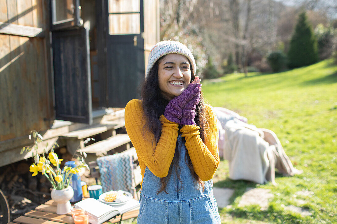 Happy young woman outside tiny cabin rental