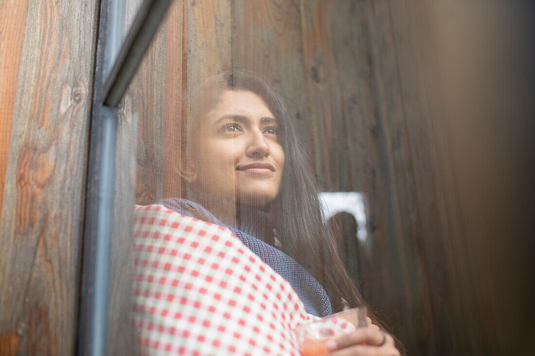 Thoughtful young woman looking out window