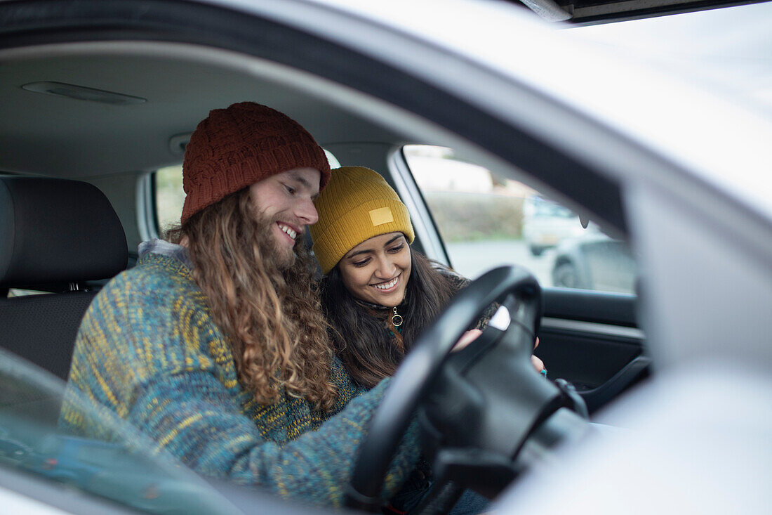 Smiling young couple inside car