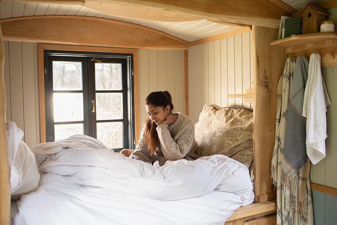 Young woman reading in bed