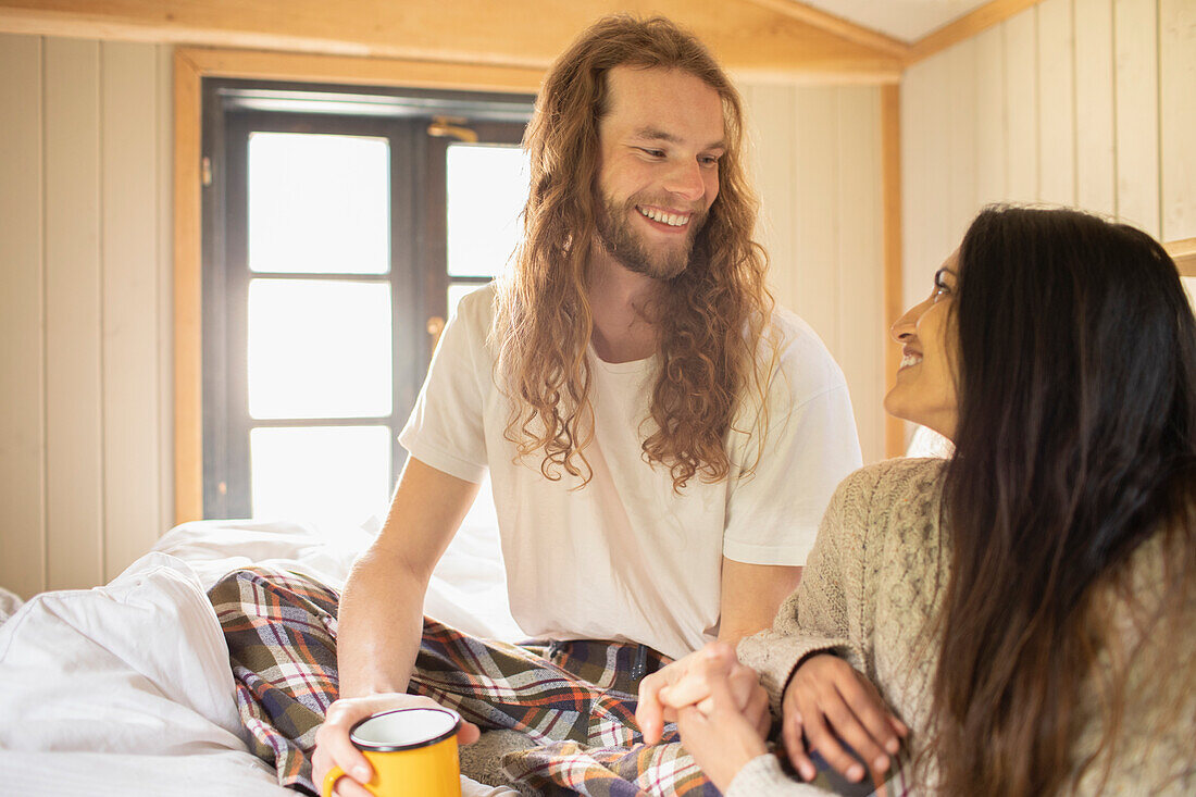 Happy young couple talking in bed