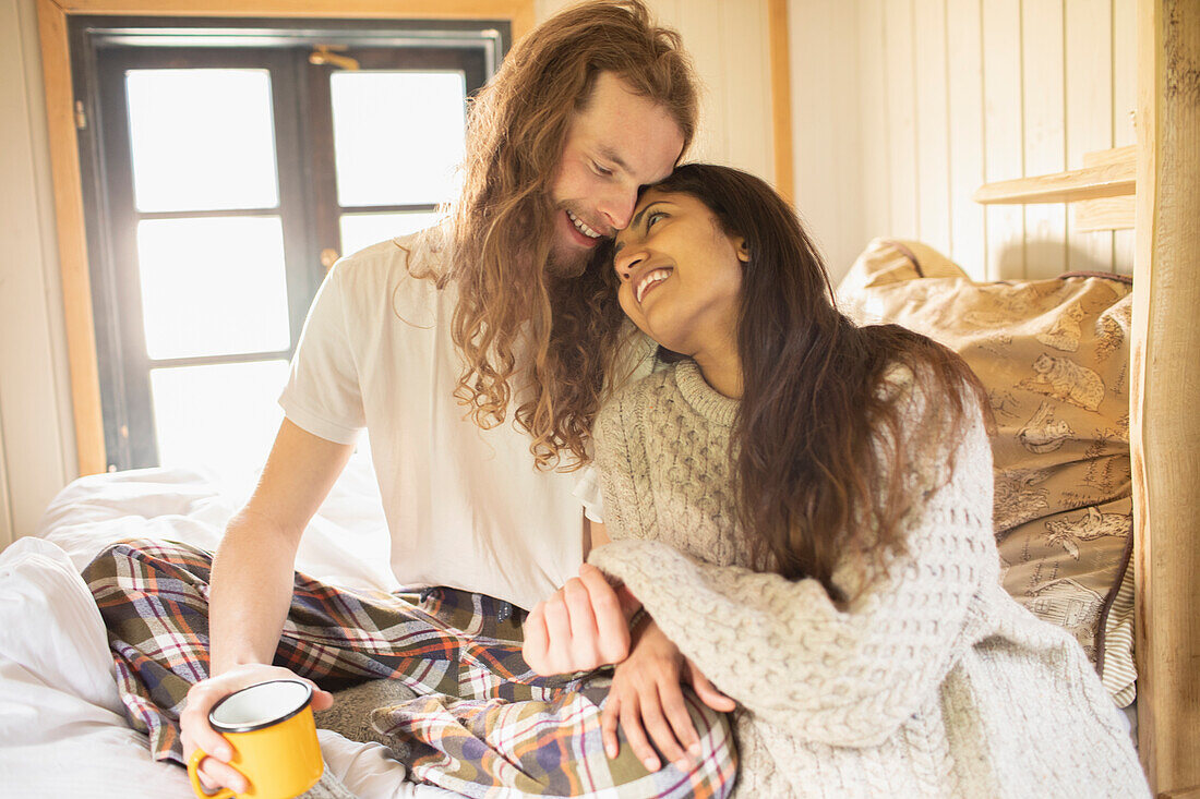 Happy young couple cuddling in bed