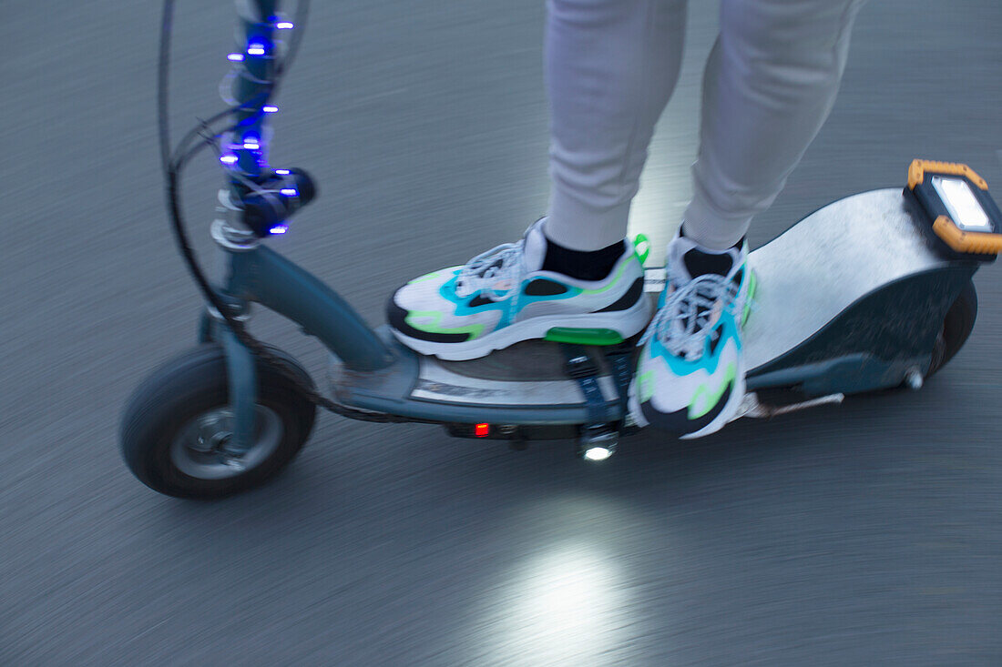 Man riding illuminated electric scooter