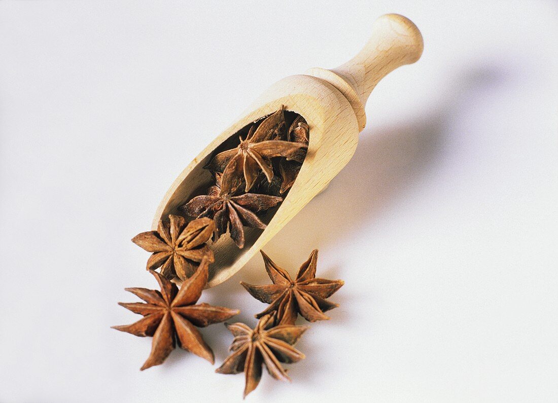 Star Anise Falling From a Wooden Scoop