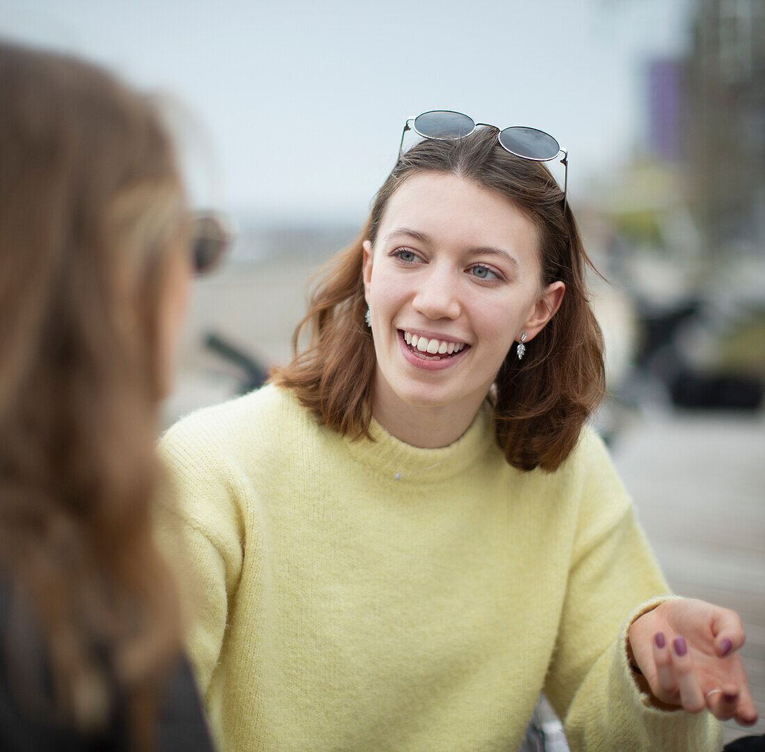 Happy young woman talking with friend