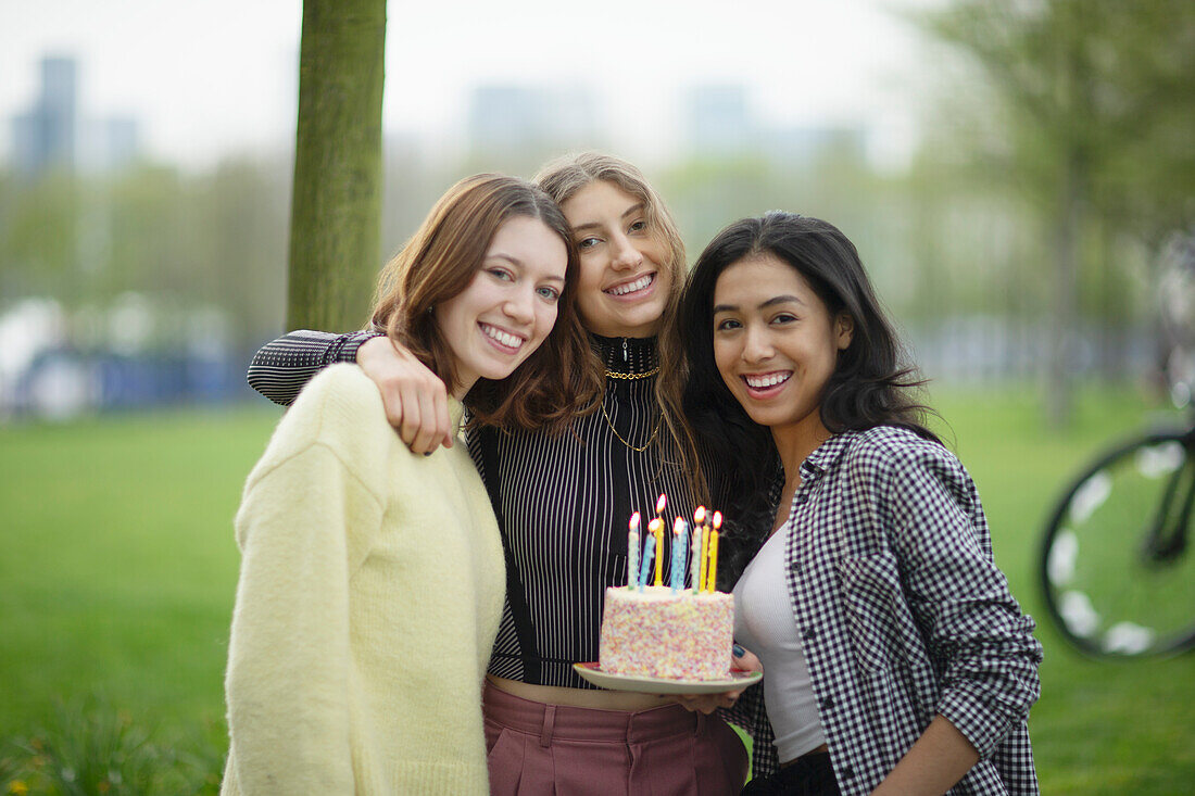 Happy young female friends celebrating birthday in park