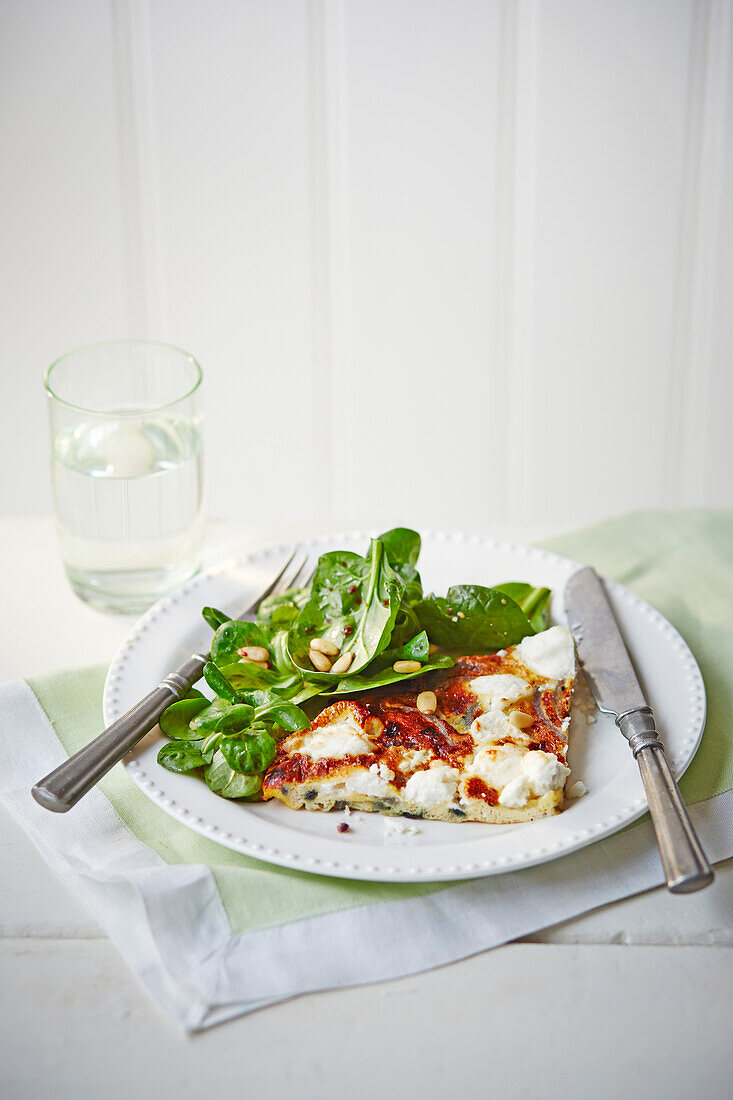 Slice of frittata with nutty green salad and balsamic dressing