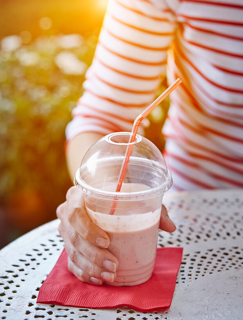 Avocado-and-strawberry smoothie in a take away cup