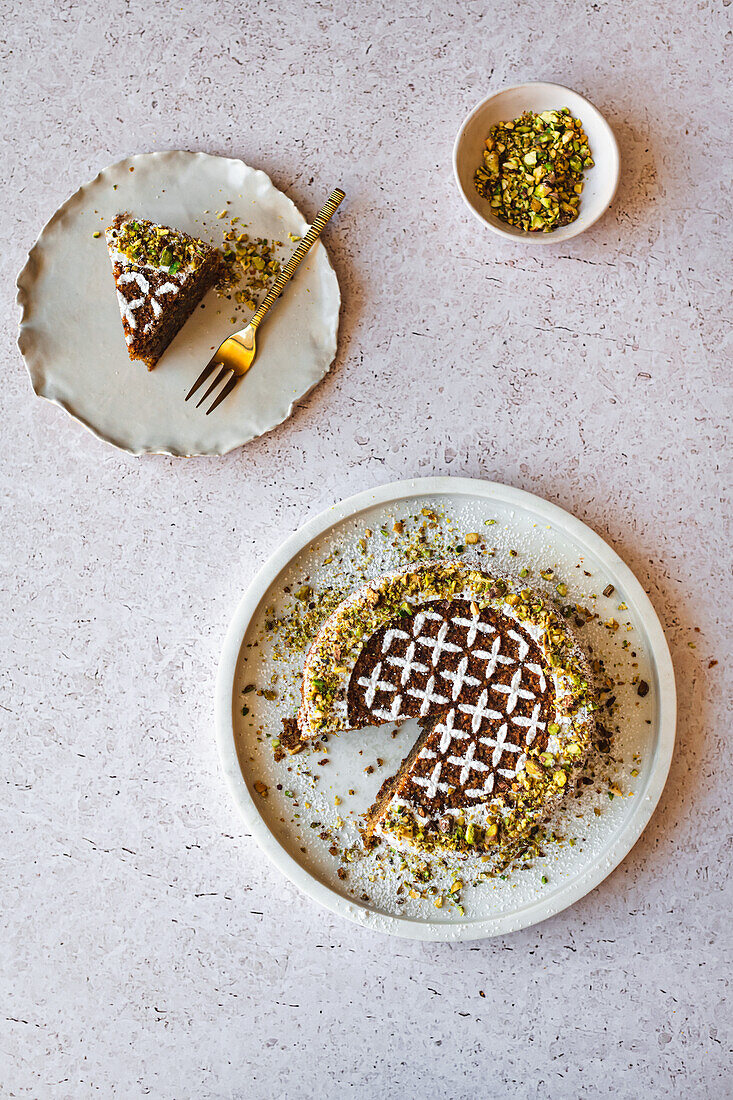 Gluten free pistachio and almond cake with patterned icing sugar decoration