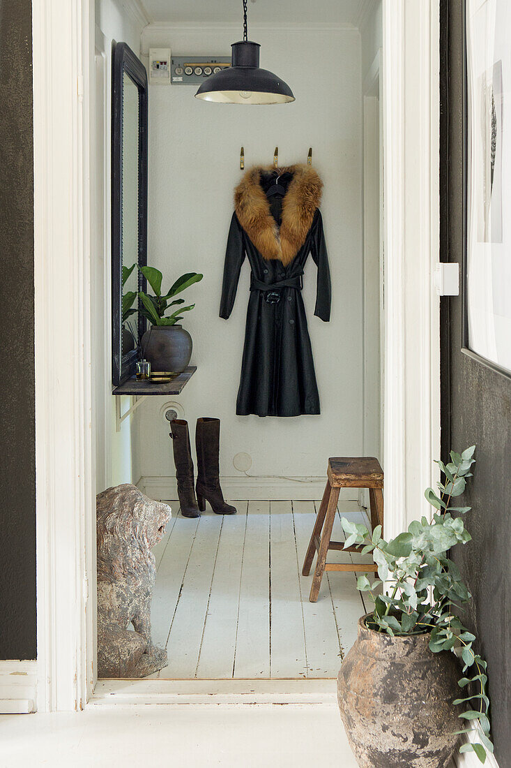 Entrance area with coat rack, plants and rustic stool