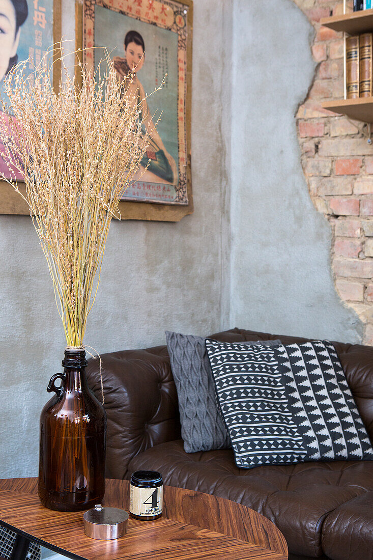 Dried flowers in brown glass bottle in a retro living room