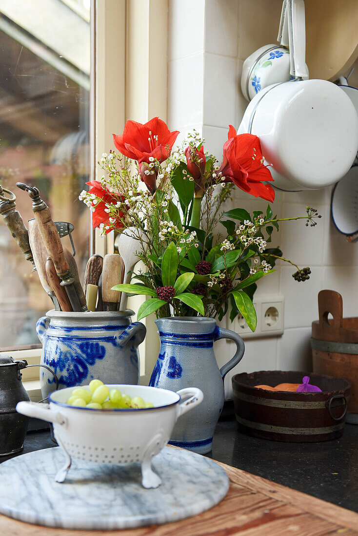 Trauben im alten Emaillesieb, Schmalztopf als Utenilo, Krug als Blumenvase