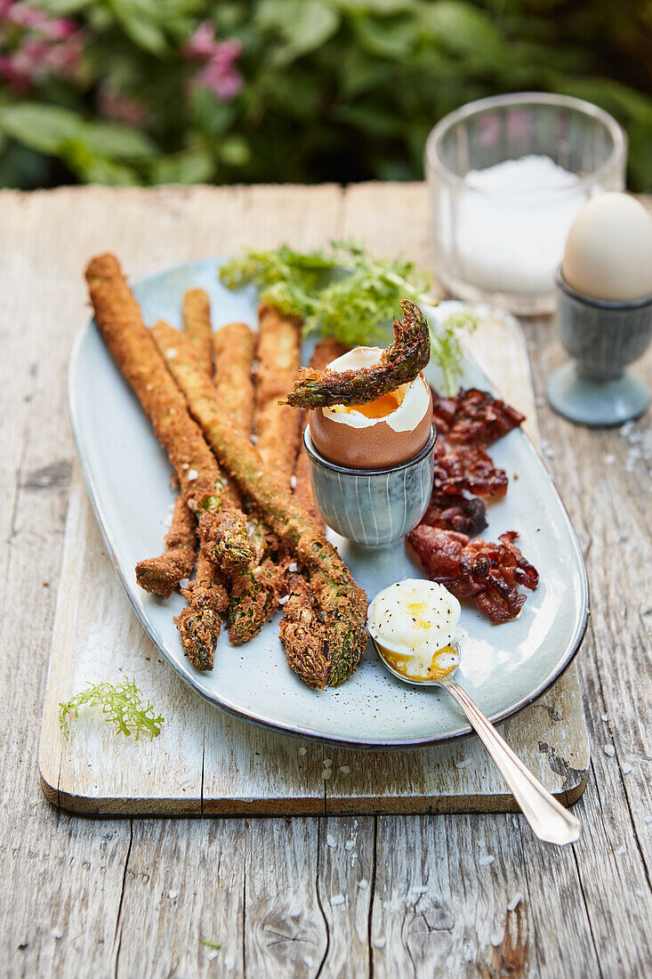 Fried green asparagus with egg and bacon