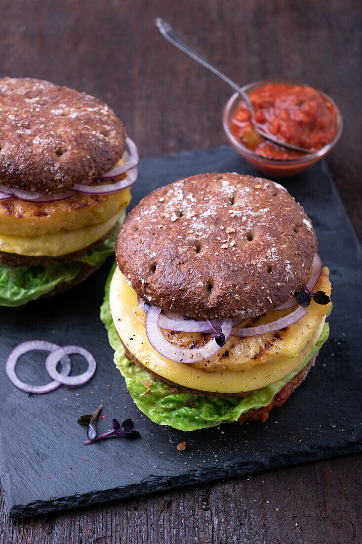 Vegan burger with bean patty, cheese substitute and grilled pineapple