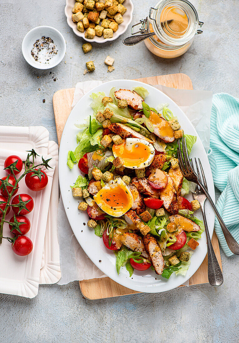 Caesar Salad mit Hähnchen, Tomaten, gekochtem Ei und Croûtons