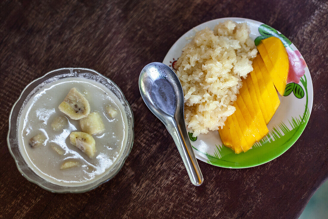 Thai desserts: Banana in coconut milk and sticky rice with mango