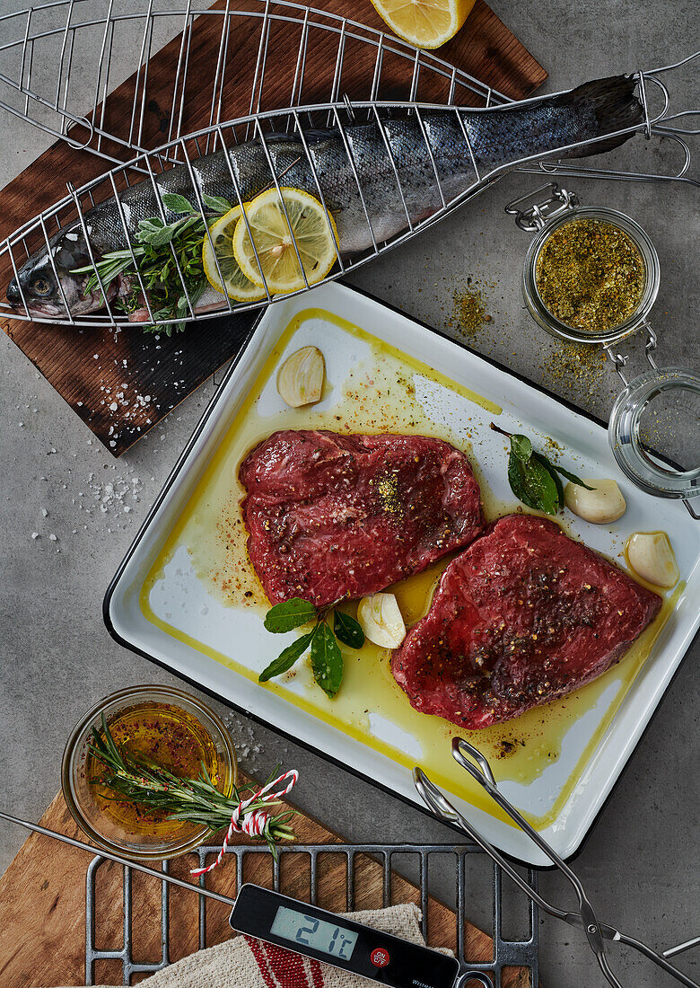 Marinated beef fillets and trout in a grill rack