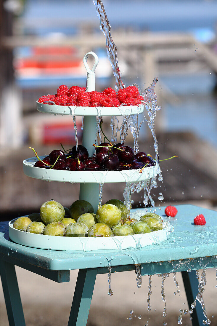 Greengage plum, cherries, and raspberries on a a tiered dessert tray (for fasting)